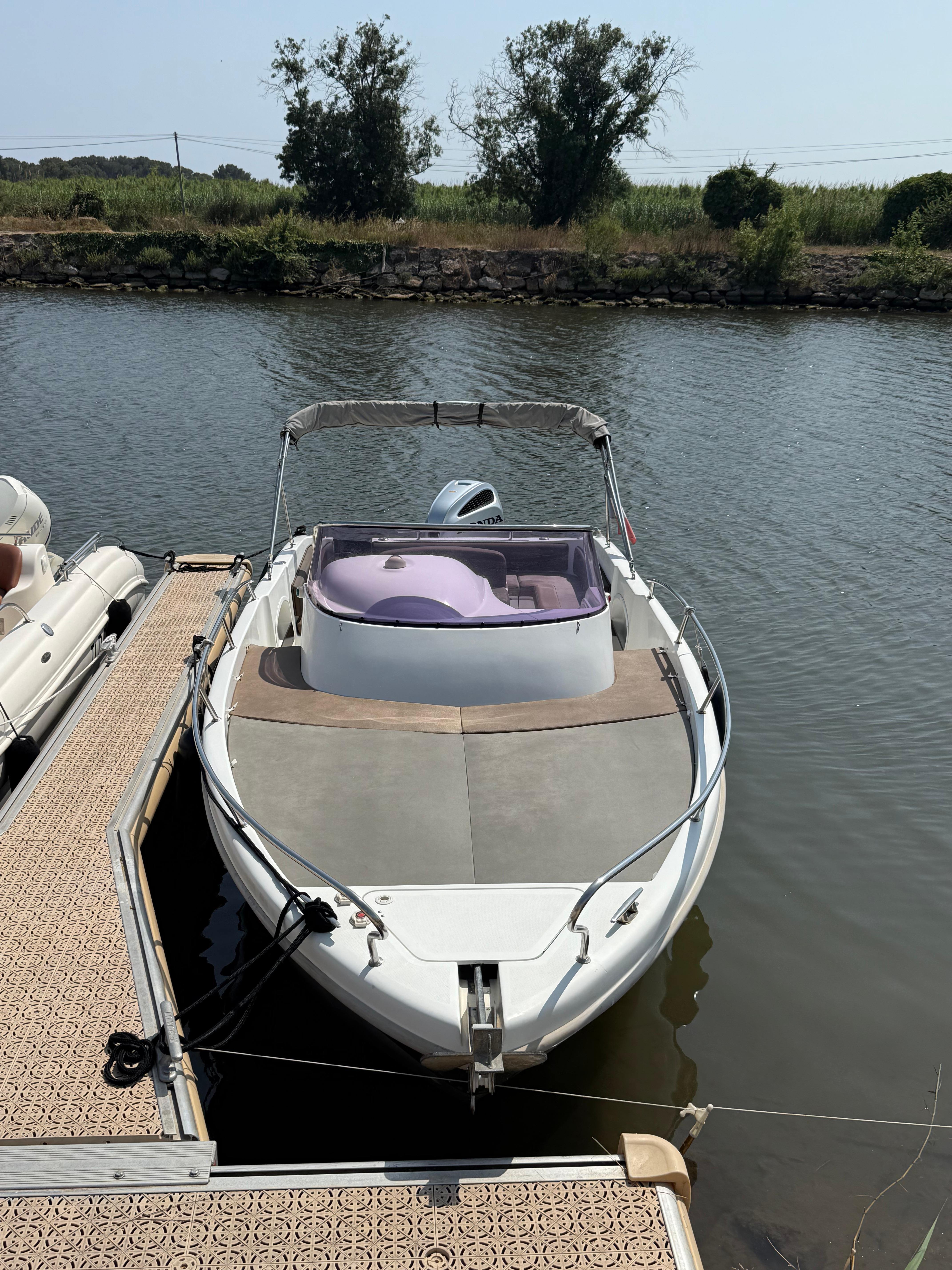 Saver 7.5 wa Saver 7.5 wa 2018 boat docked on calm water, surrounded by greenery.