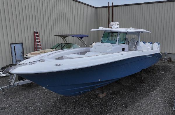 HCB 42 Lujo 2025 HCB 42 Lujo boat with blue hull, docked outdoors near a warehouse.