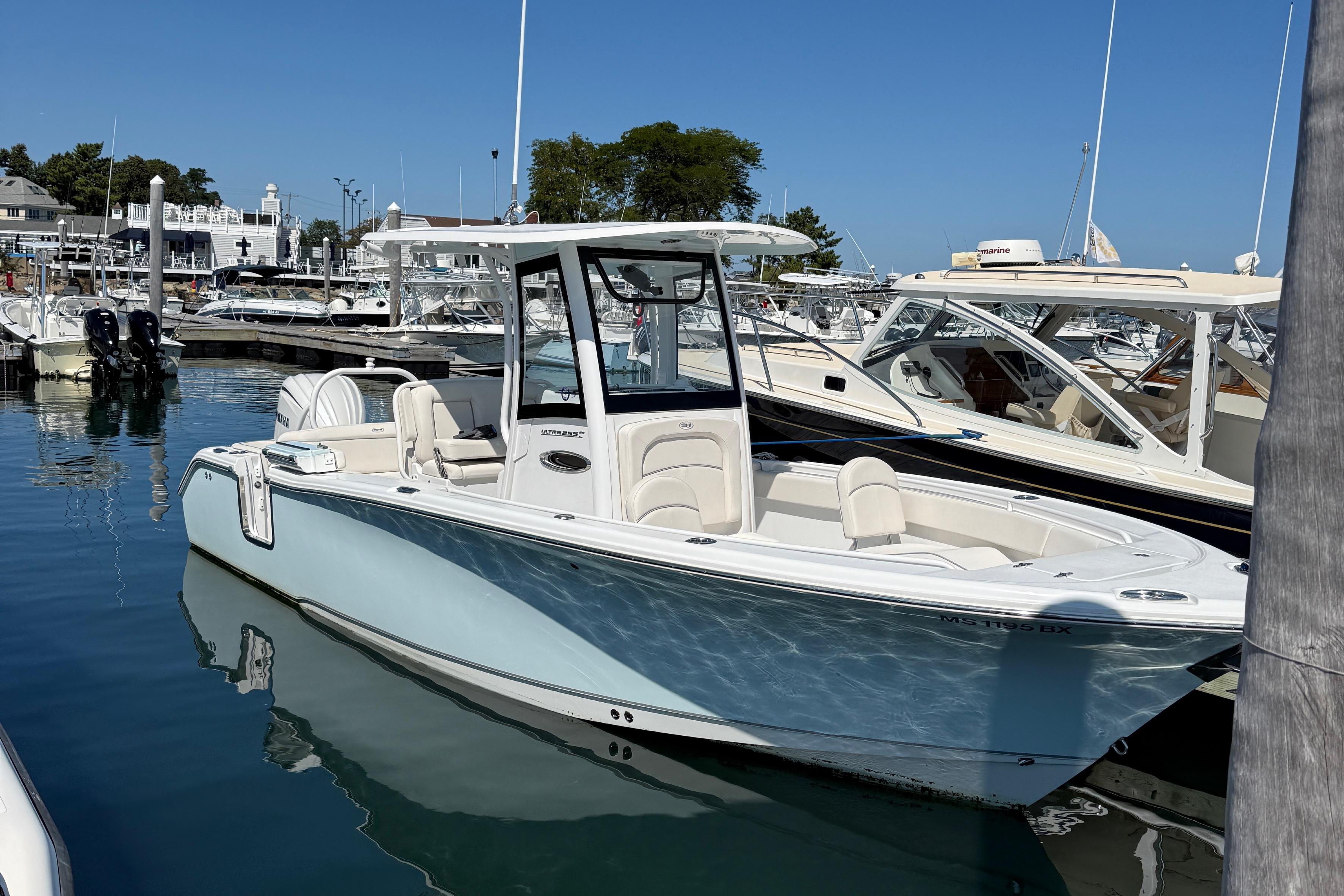 Sea Hunt Ultra 255 SE 2025 Sea Hunt Ultra 255 SE boat docked in a marina under clear blue skies.