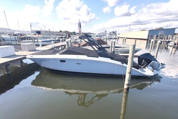 Sea Ray SDX 270 Outboard 2022 Sea Ray SDX 270 Outboard boat docked at a marina under a cloudy sky.