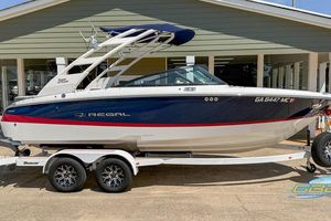 Regal LS2 Surf 2022 Regal LS2 Surf boat on trailer, blue and white design, parked outside a building.