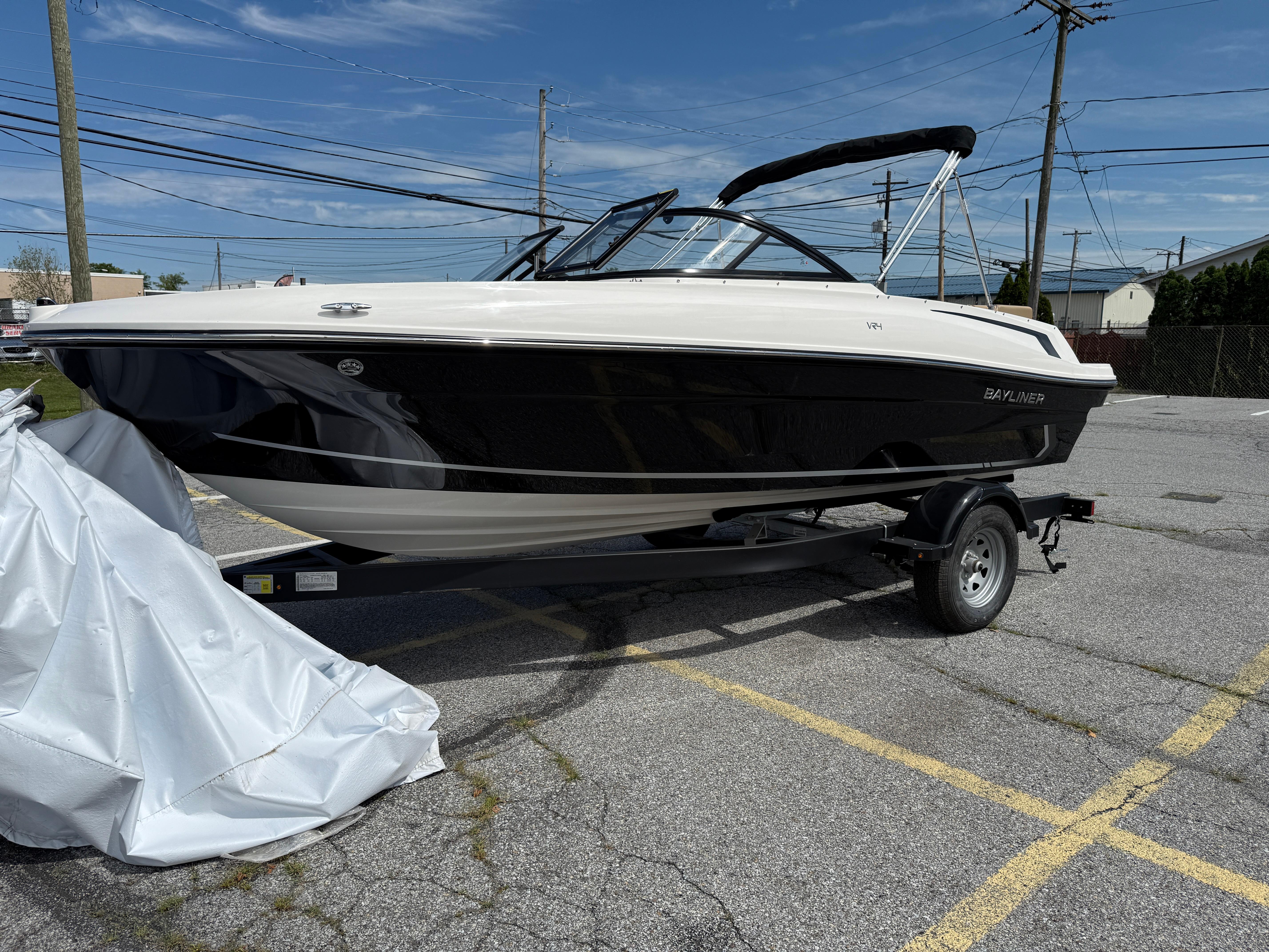 Bayliner VR4 Bowrider I/O 2025 Bayliner VR4 Bowrider I/O boat on trailer in parking lot.