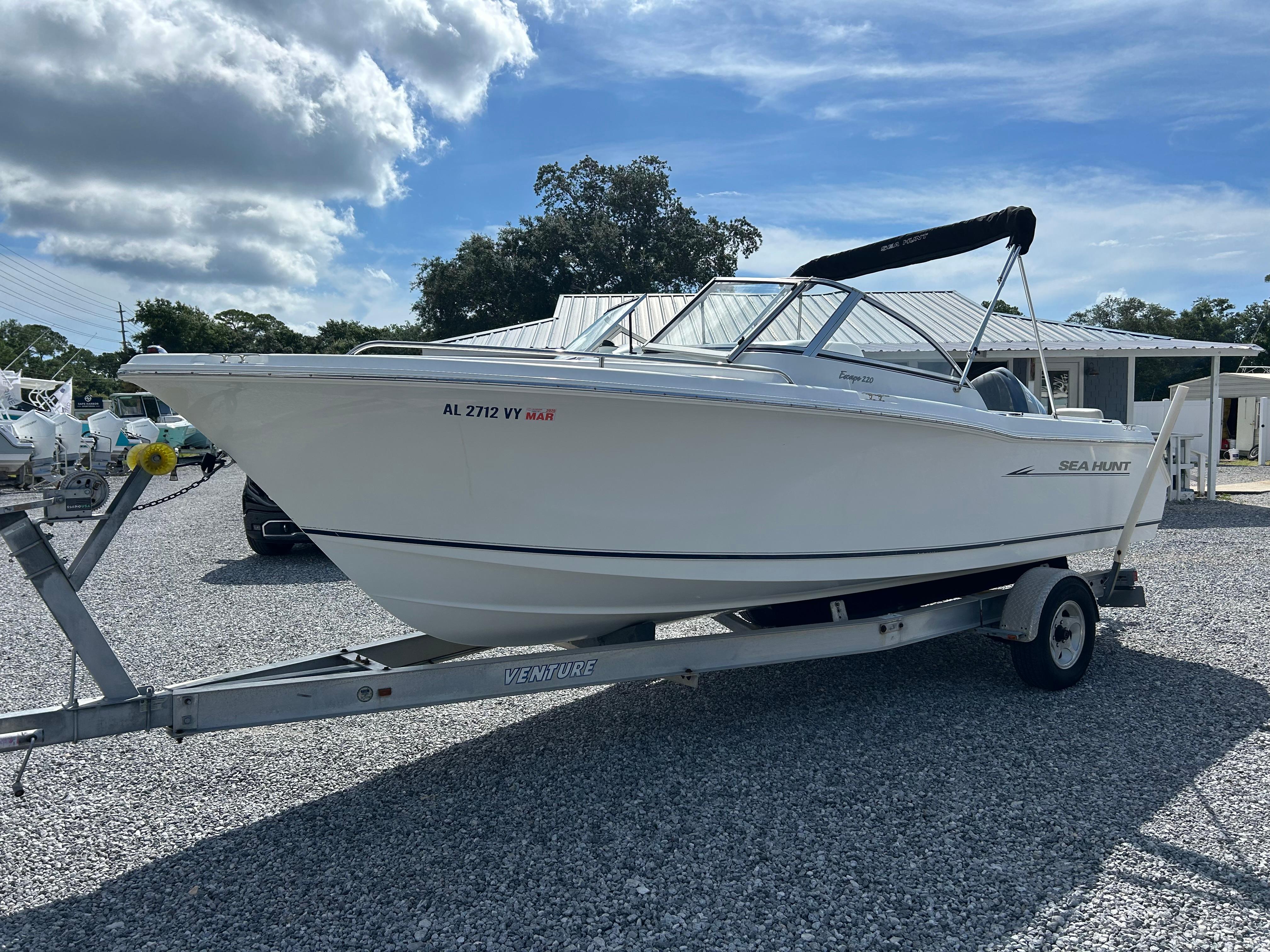 Sea Hunt Escape 220 DL 2007 Sea Hunt Escape 220 DL boat on trailer under cloudy sky.