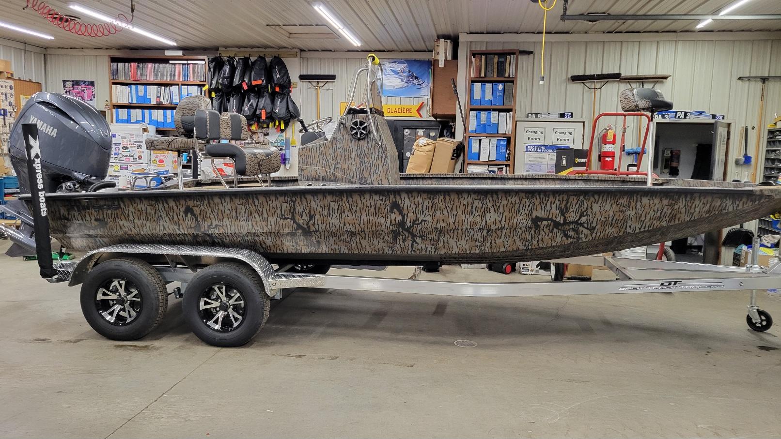 Xpress H210 Bay w/ Yamaha 150 (In stock!) 2025 Xpress H210 Bay boat with Yamaha 150 engine in a showroom.