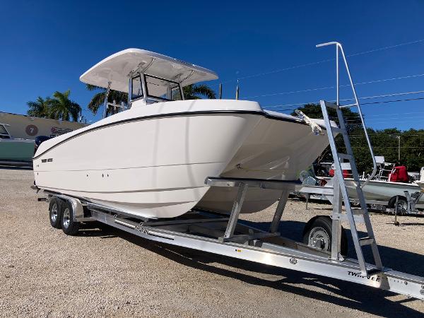Twin Vee 260 GFX 2025 Twin Vee 260STX boat on trailer, parked outdoors under clear blue sky.