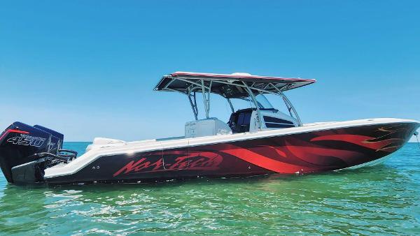 Nor-Tech Center Console 2020 Nor-Tech Center Console boat with vibrant red design on calm water.
