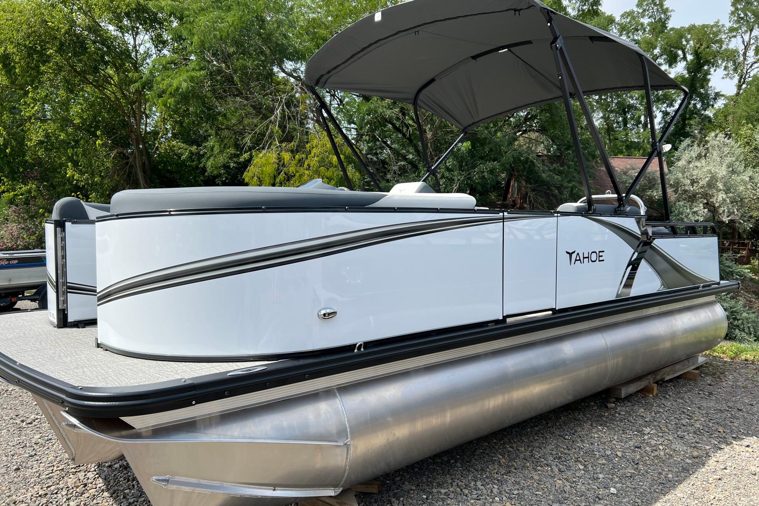 Tahoe TRITOON 2185 2026 Tahoe TRITOON 2185 pontoon boat with canopy, parked on gravel.
