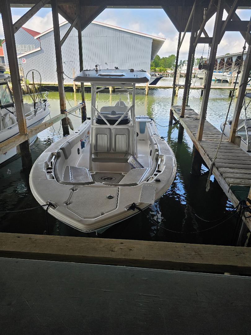 Sea Fox 248 Commander 2022 Sea Fox 248 Commander boat docked in a marina under a wooden shelter.