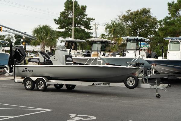 Turner Boatworks 2500 VS 2025 Turner Boatworks 2500 VS on trailer in parking lot, surrounded by other boats.