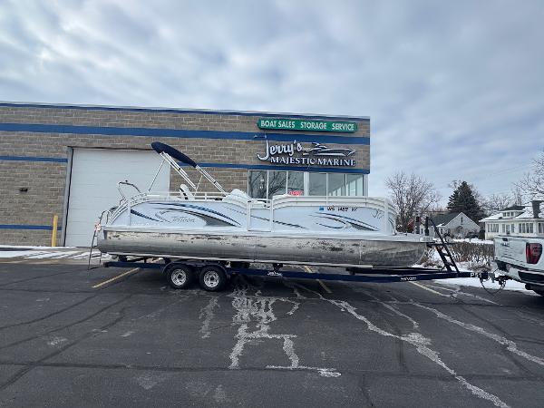 JC Neptoon 25TT 2022 JC Neptoon 25TT pontoon boat on trailer outside marine sales and service building.