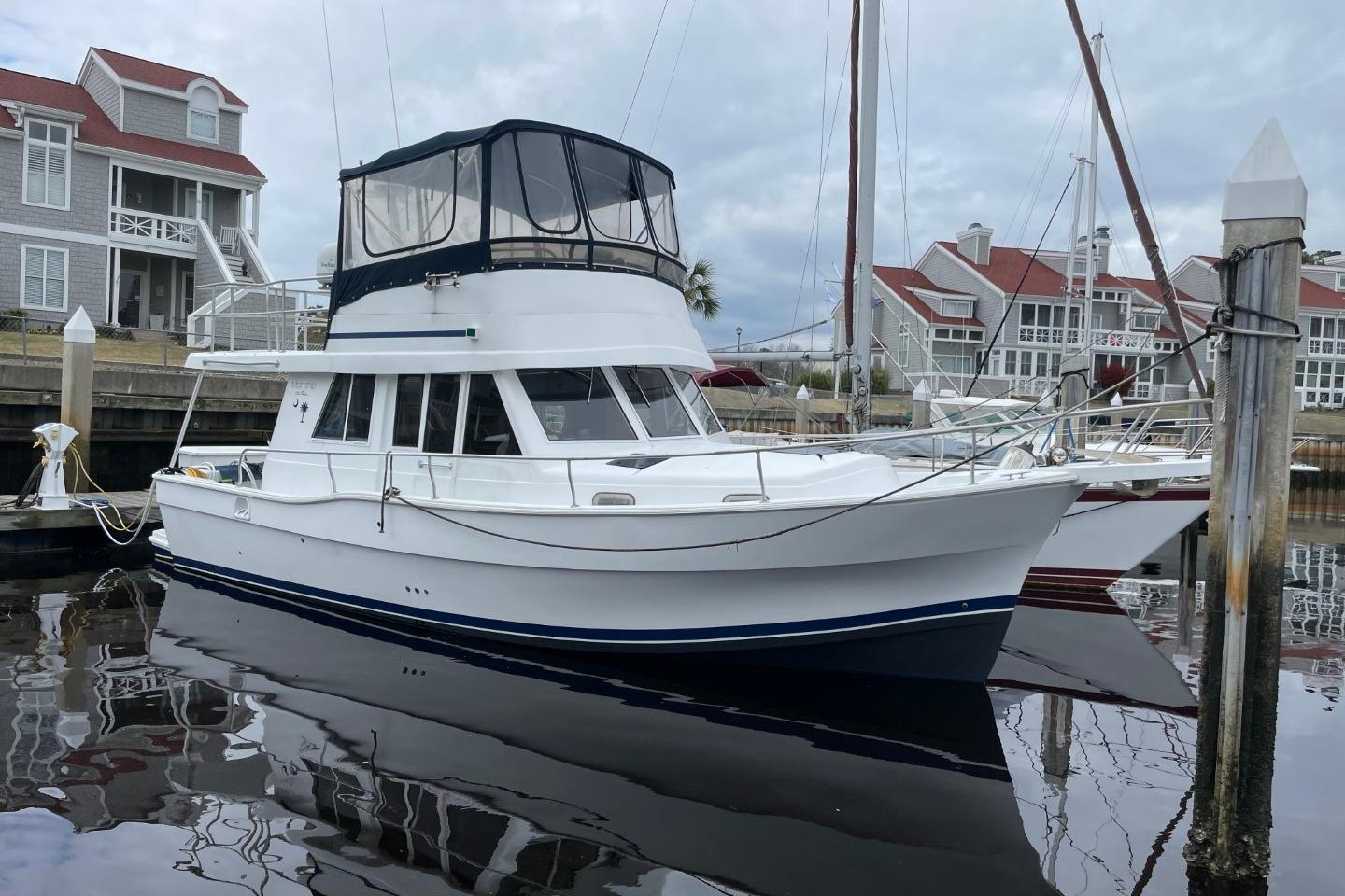 Mainship 350 Trawler 1997 Mainship 350 Trawler docked near waterfront homes, reflecting on calm water.