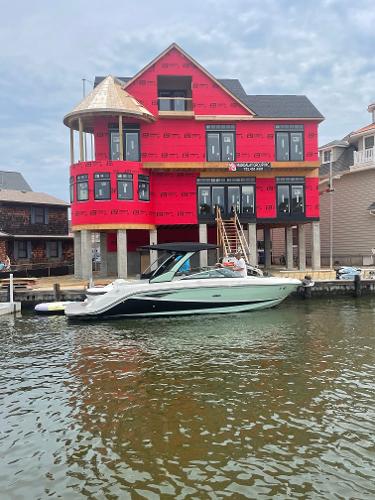 Sea Ray SLX 280 2022 Sea Ray SLX 280 boat docked near a waterfront house under construction.