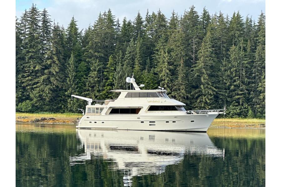 Hampton 720 Skylounge LRC 2014 Hampton 720 Skylounge LRC yacht on calm water, surrounded by lush forest.