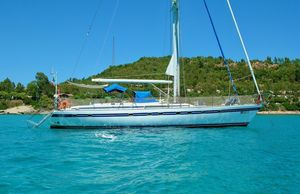 Tayana 55 Sailing yacht Tayana 55, 1992 model, anchored in turquoise waters near a lush coastline.