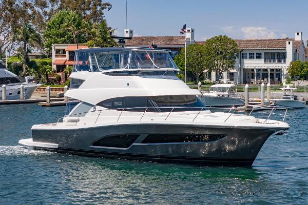 Riviera 46 Sports Motor Yacht 2025 Riviera 46 Sport Motor Yacht cruising in a marina, showcasing sleek design and luxury.