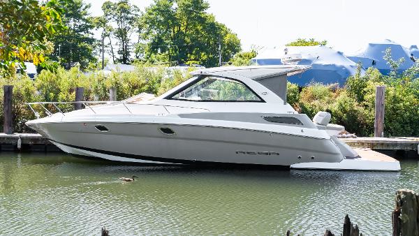 Regal 35 Sport Coupe 2012 Regal 35 Sport Coupe boat docked in a serene marina setting.