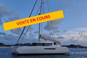 NEEL 47 2019 NEEL 47 trimaran with "Vente en Cours" banner, anchored in scenic waters.