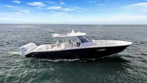 Pursuit S 428 Sport 2023 Pursuit S 428 Sport boat cruising on open water under clear blue sky.