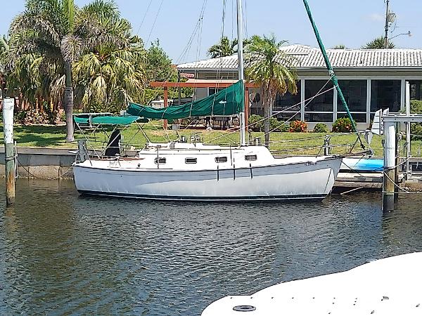 Com-Pac 27/3 2017 Com-Pac 27/3 sailboat docked near a waterfront home with palm trees.