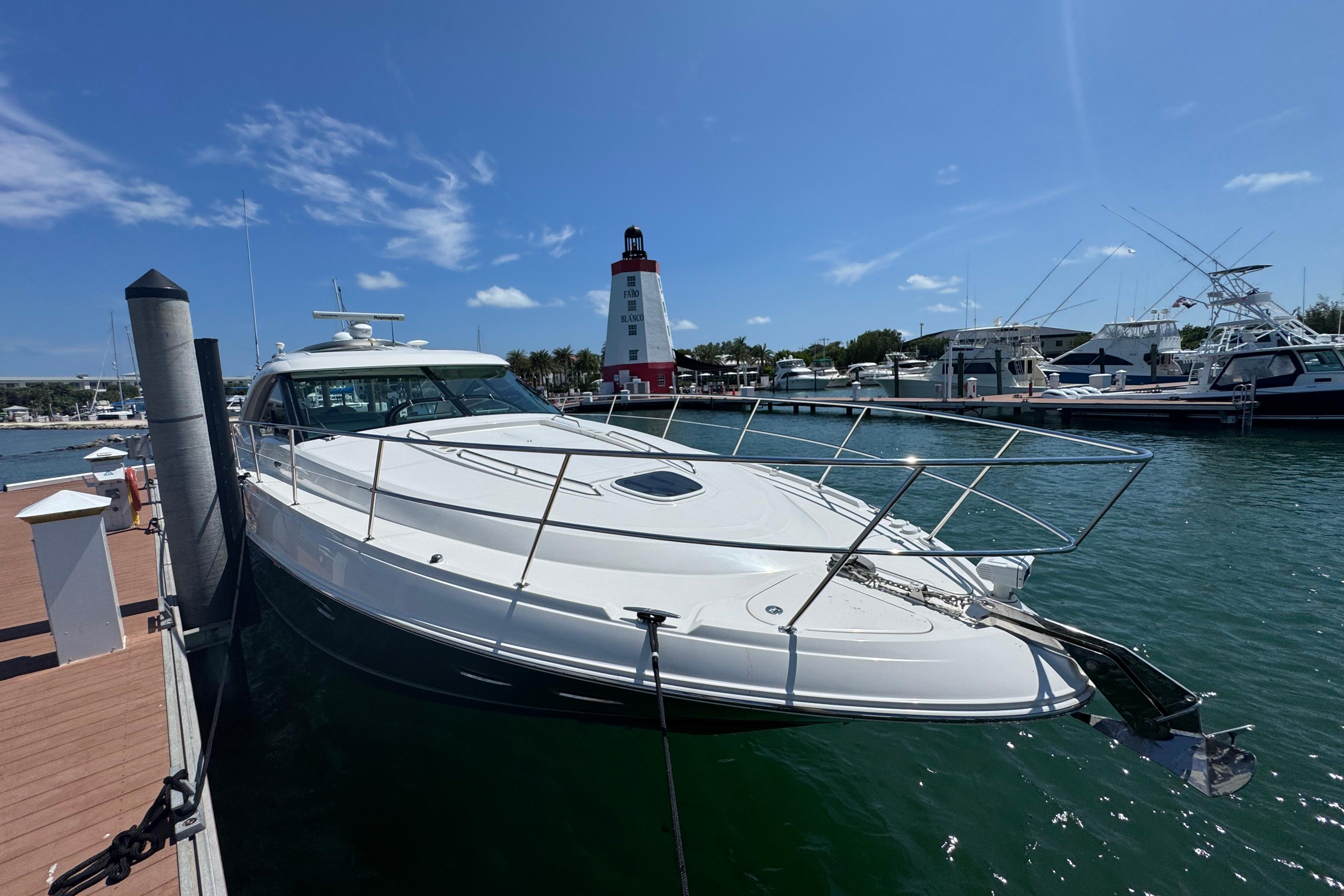 Sea Ray 470 Sundancer 2012 Sea Ray 470 Sundancer yacht docked near a lighthouse on a sunny day.