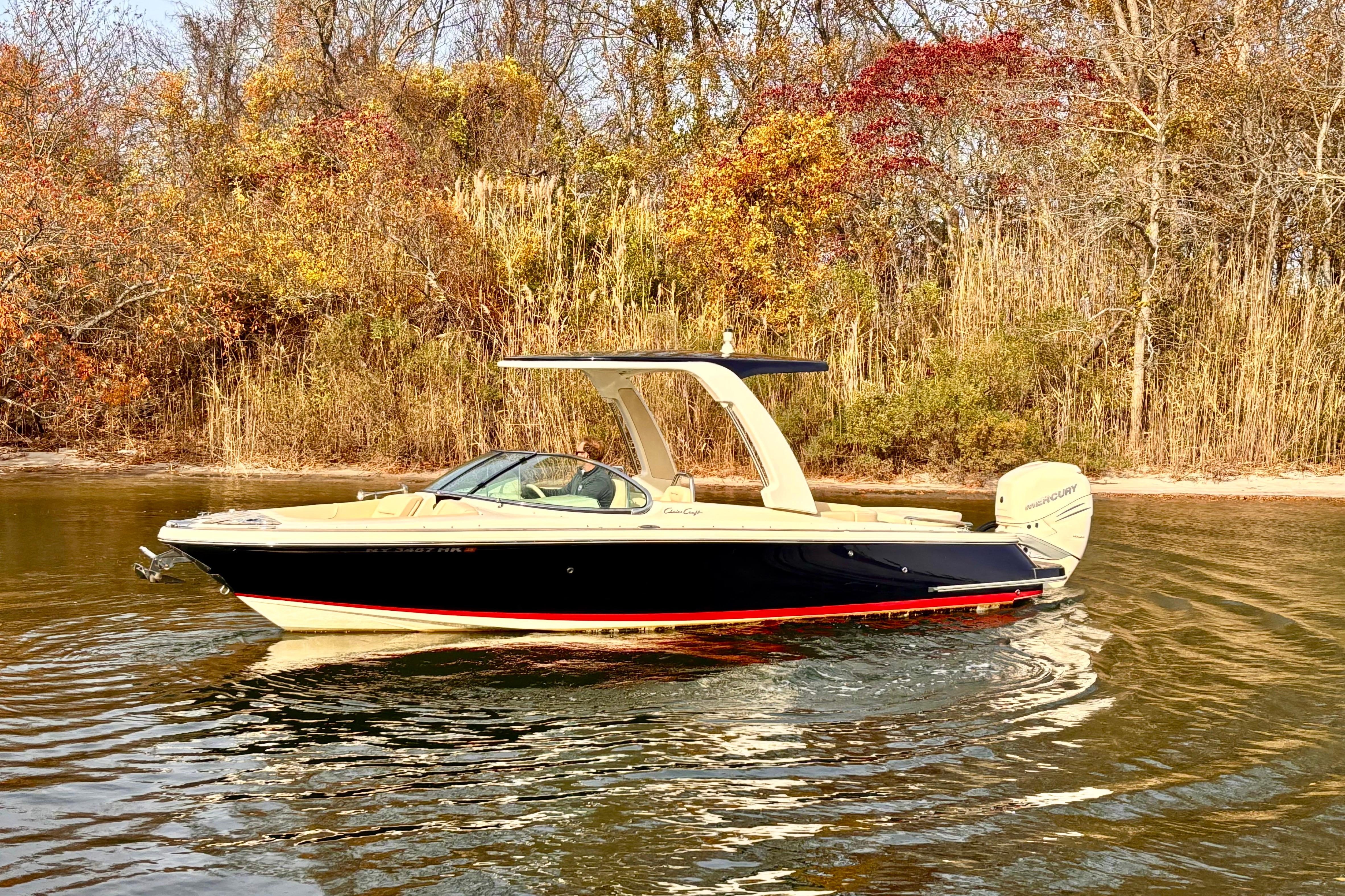 Chris-Craft Launch 25 GT 2022 Chris-Craft Launch 25 GT boat on calm water with autumn foliage background.