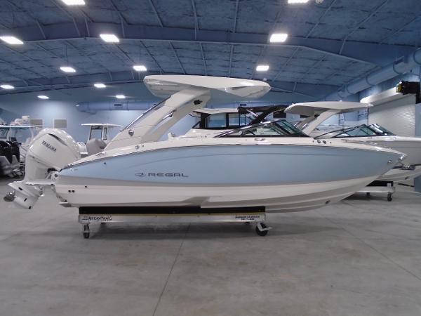 Regal LX6 2025 Regal LX6 boat in showroom, side view, white and blue design.