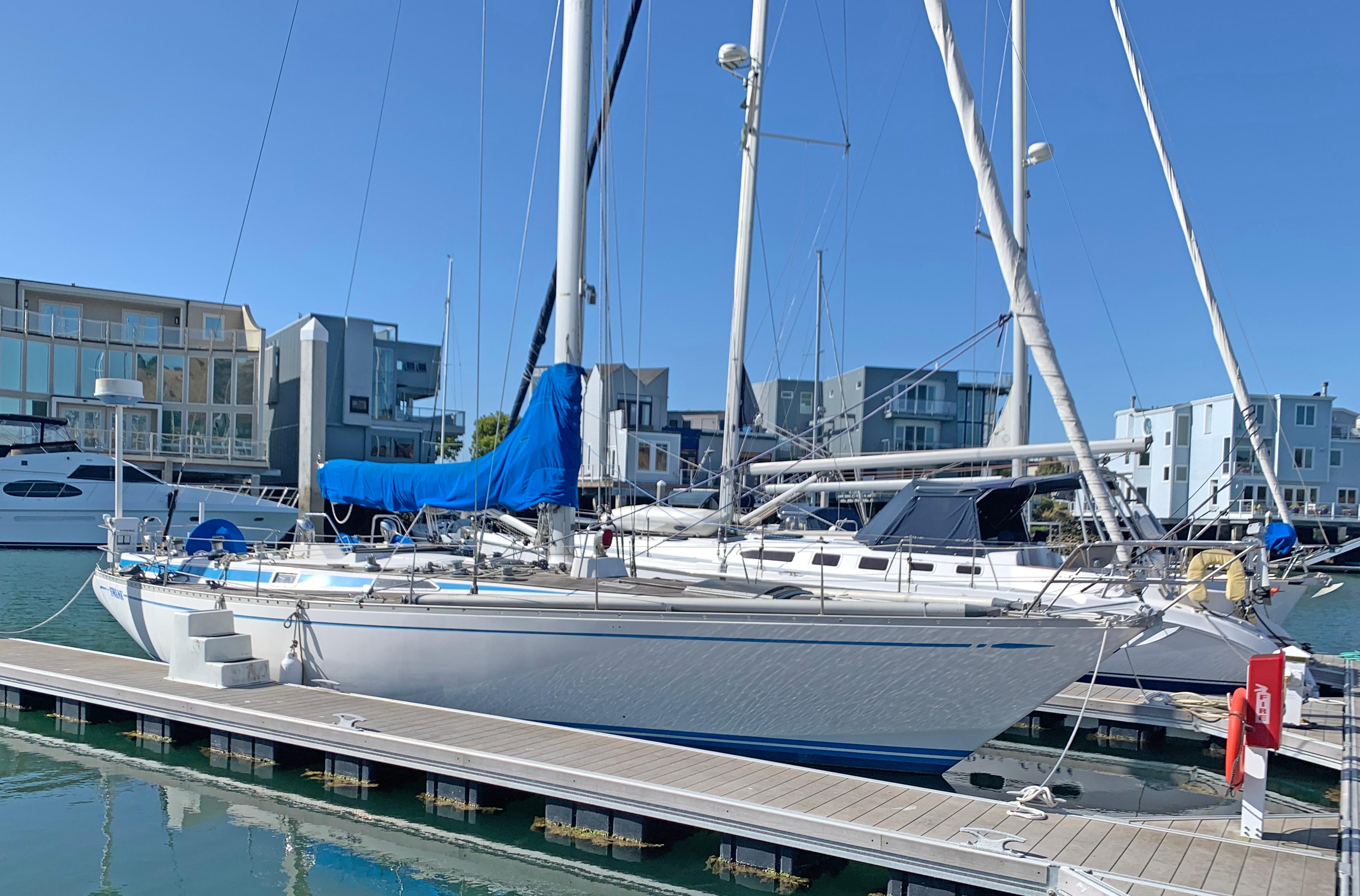 Nautor Swan 431 1977 Nautor Swan 431 sailboat docked in a marina, surrounded by modern buildings.