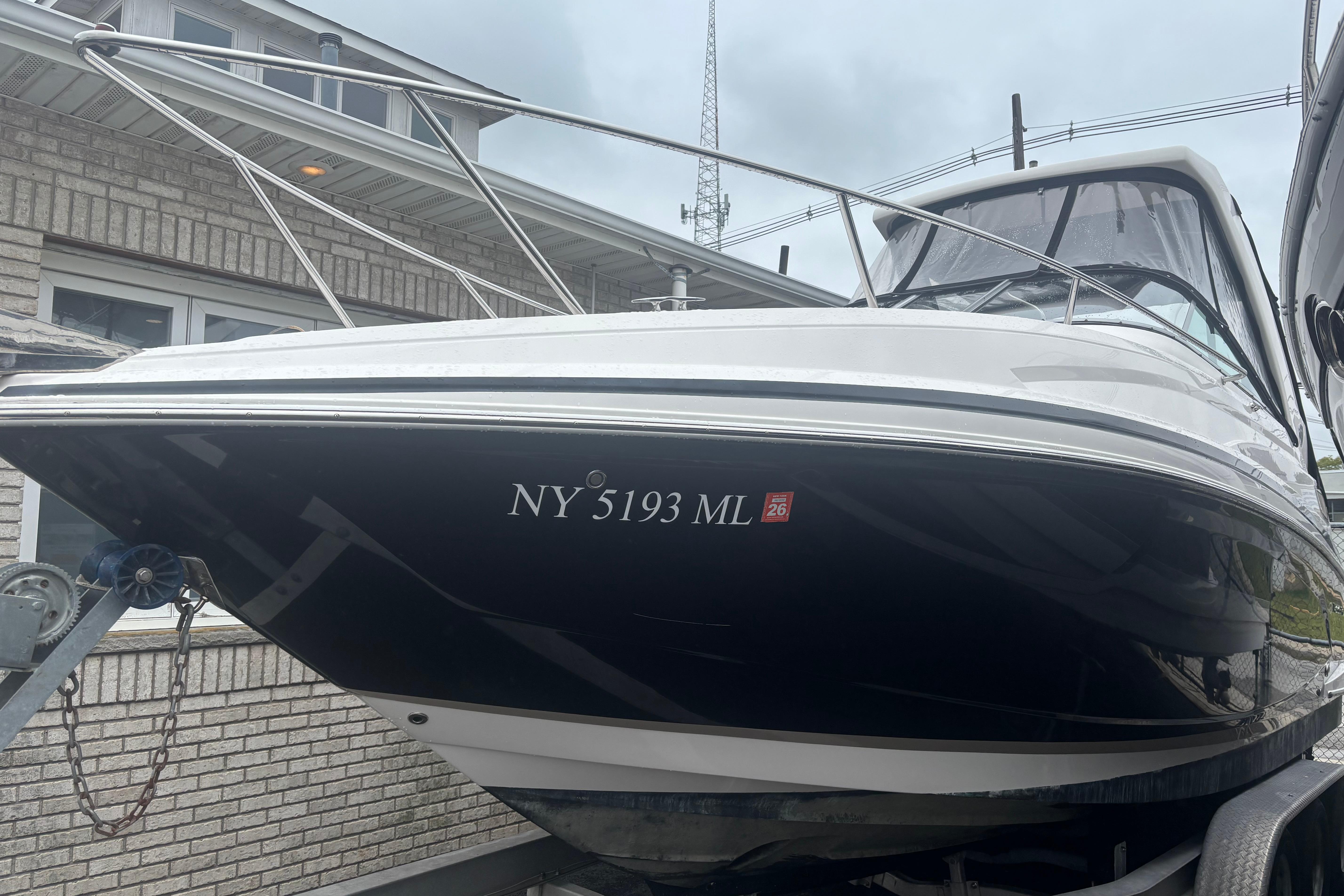 Regal 28 Express 2016 Regal 28 Express boat on trailer, registration NY 5193 ML, parked near brick building.