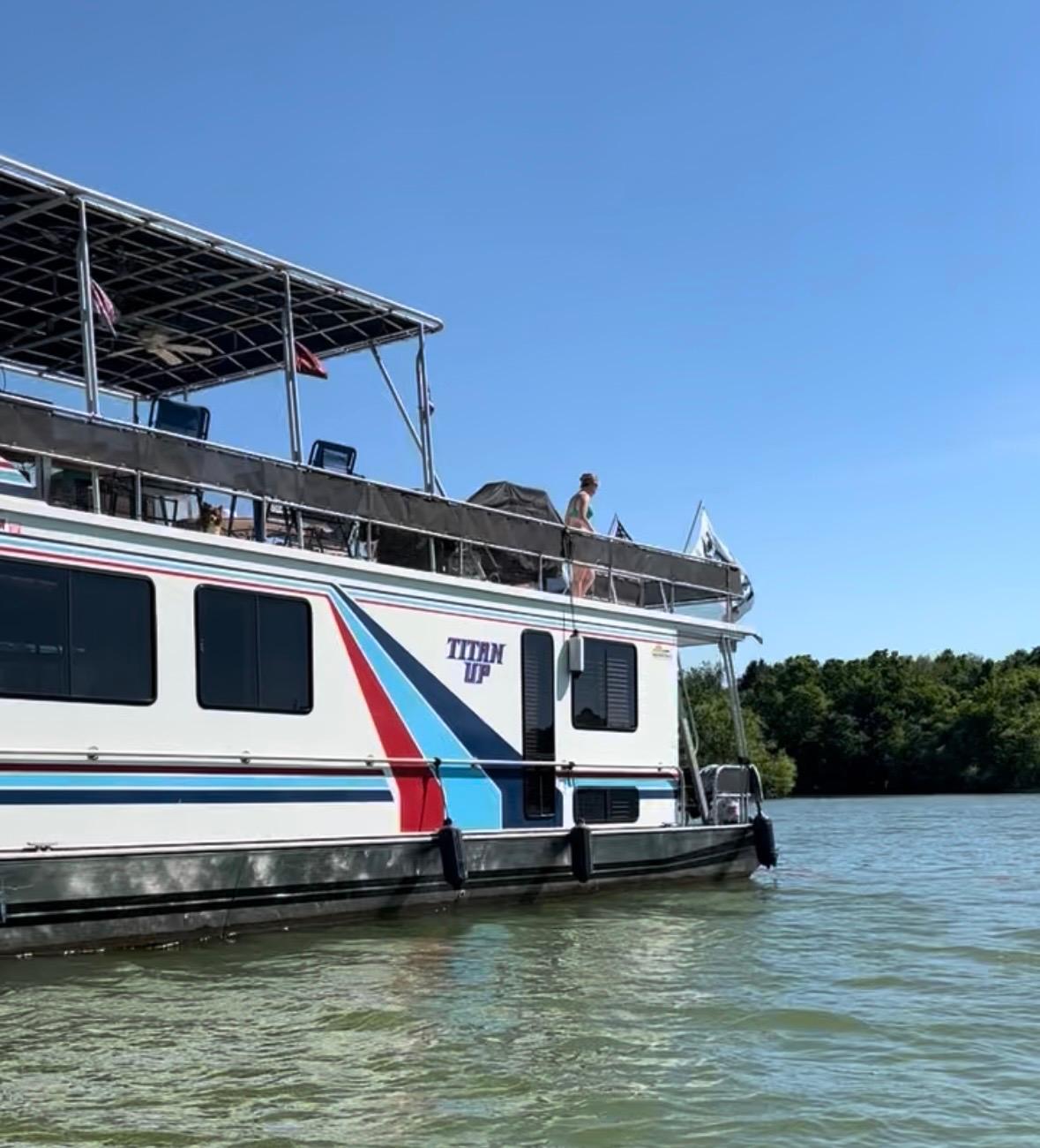Lakeview Houseboat 1994 Lakeview houseboat on water, featuring upper deck and colorful design.