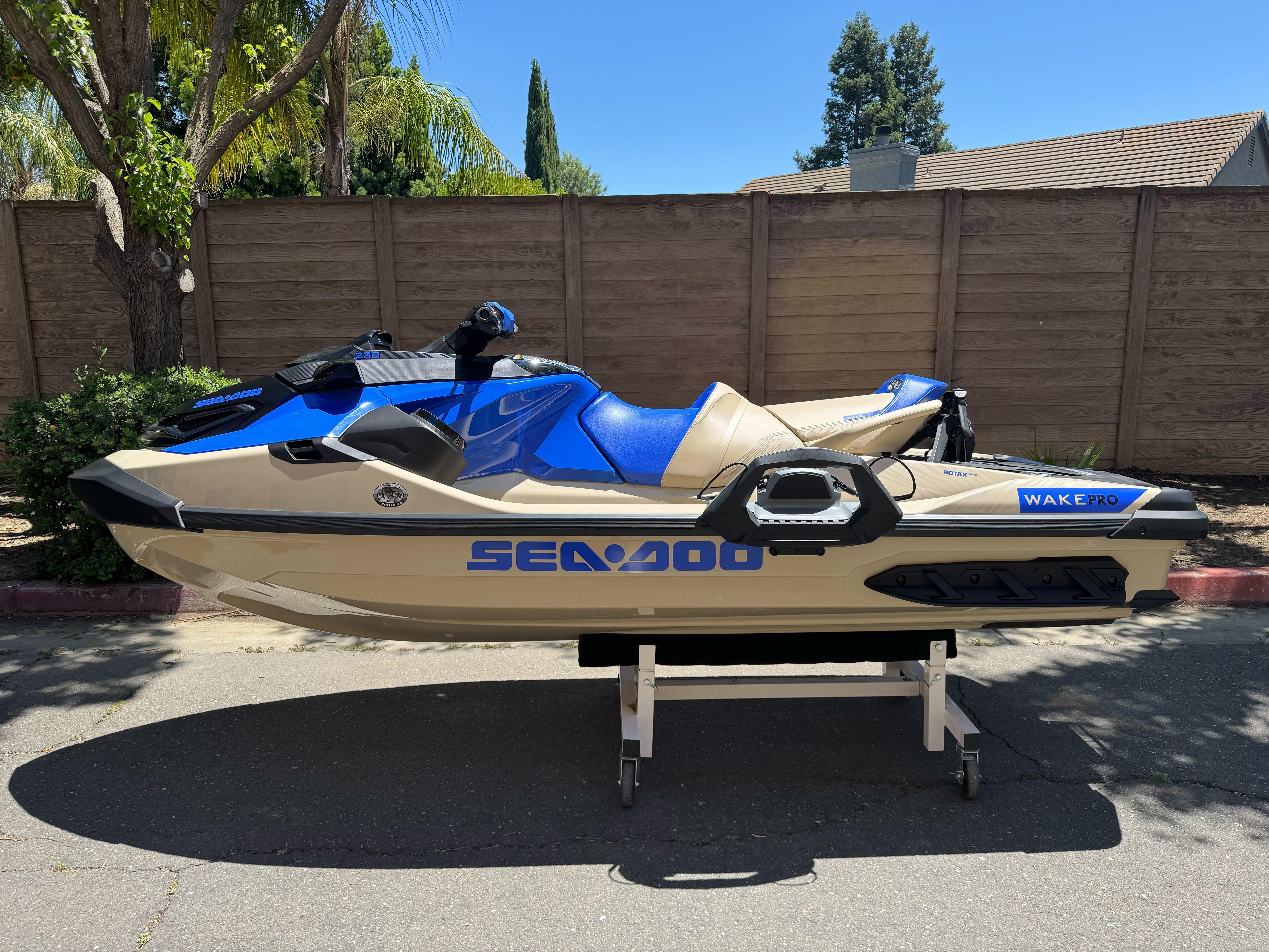 Sea-Doo Wake Pro 230 2025 Sea-Doo Wake Pro 230 jet ski, blue and beige, parked outdoors.