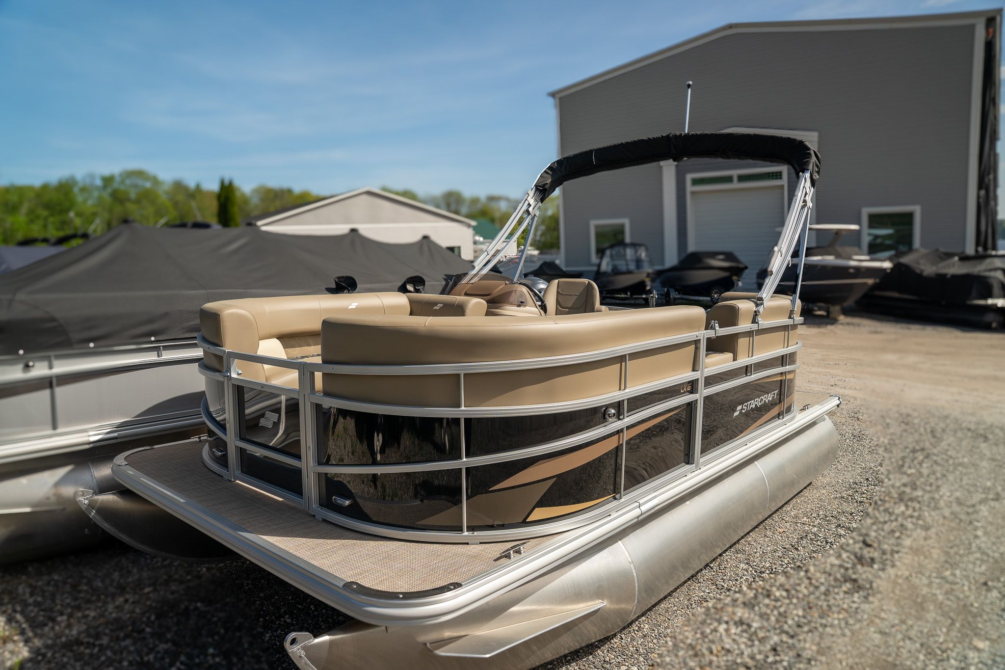 Starcraft LX 16 R 2025 Starcraft LX 16 R pontoon boat parked outdoors, featuring beige seating and sleek design.