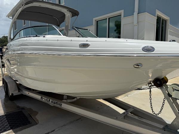 Crownline 250 XSS 2023 Crownline 250 XSS boat on trailer, parked outside a building.