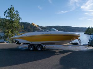 Rinker 272 Captiva 2007 Rinker 272 Captiva boat on trailer by scenic lake and forest backdrop.