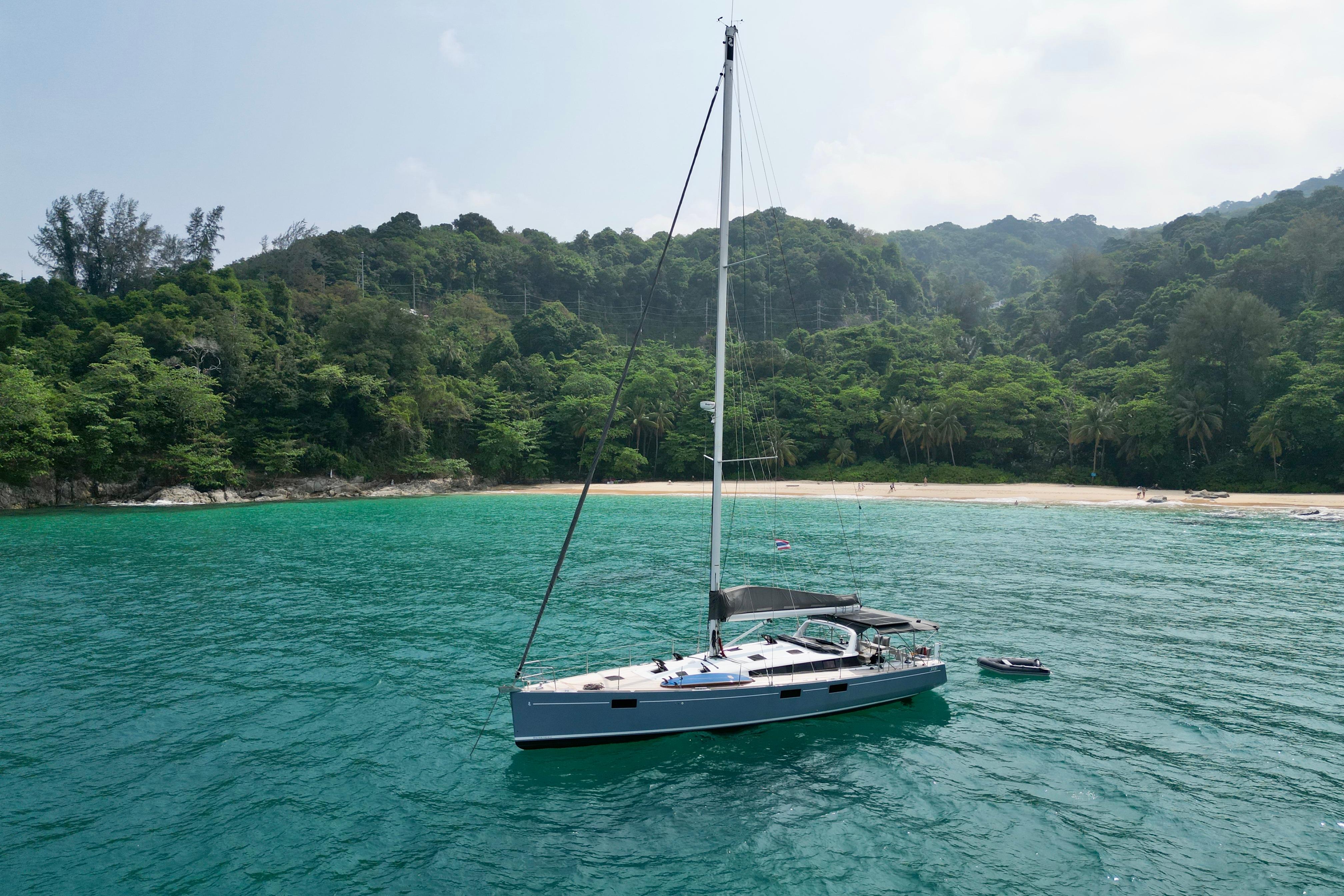 Beneteau Sense 55 Sailing yacht Beneteau Sense 55 (2012) anchored near lush tropical beach.
