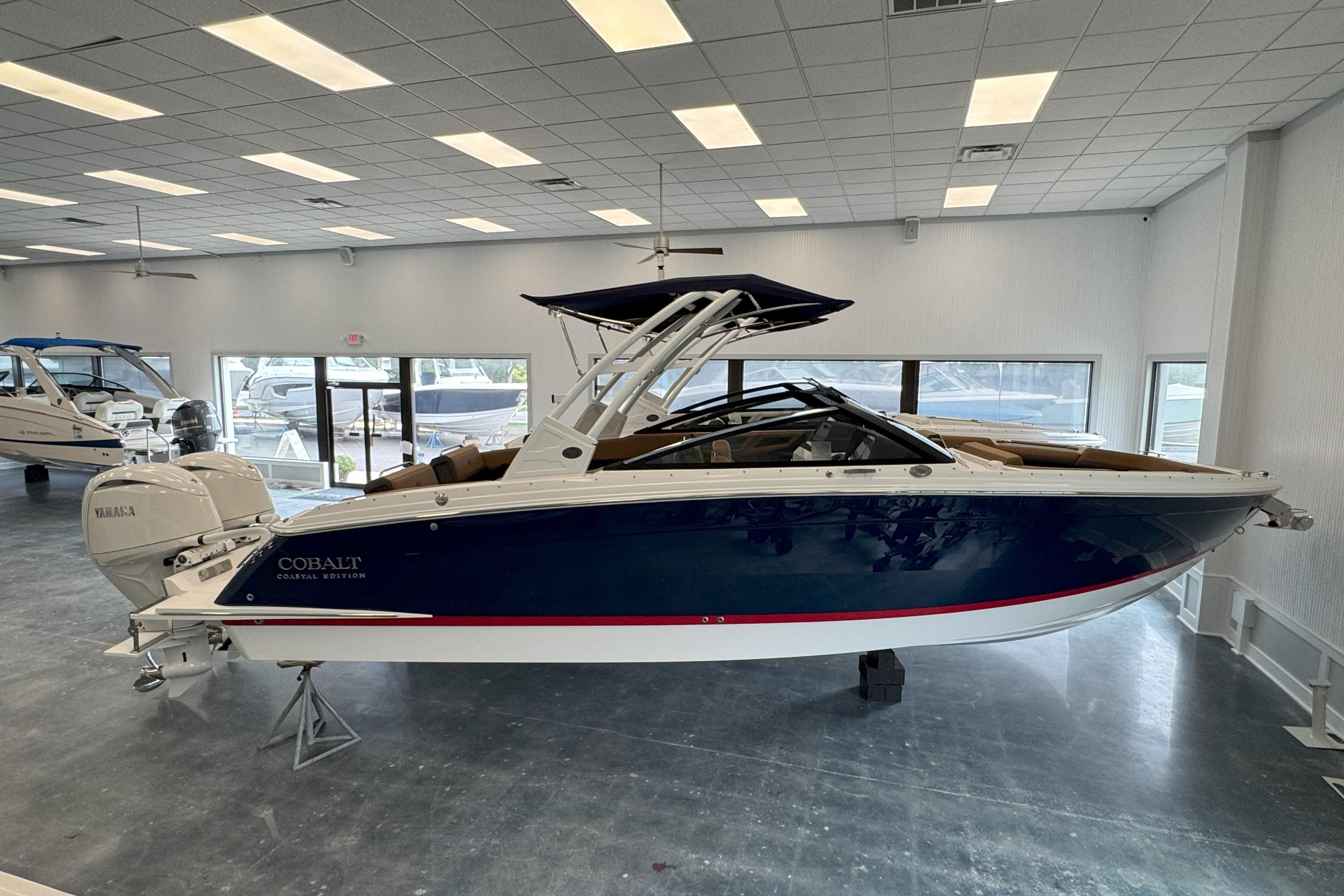Cobalt R8 Outboard 2025 Cobalt R8 Outboard boat in showroom, blue hull, white interior, Yamaha engine.