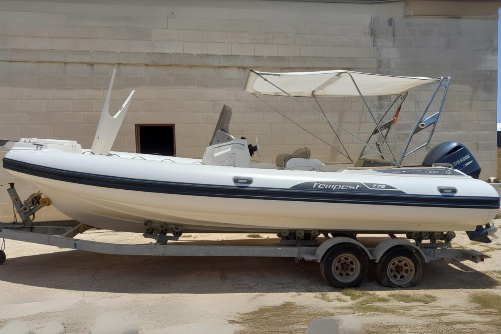 Capelli Tempest 775 2016 Capelli Tempest 775 boat on trailer, white with canopy, parked outdoors.