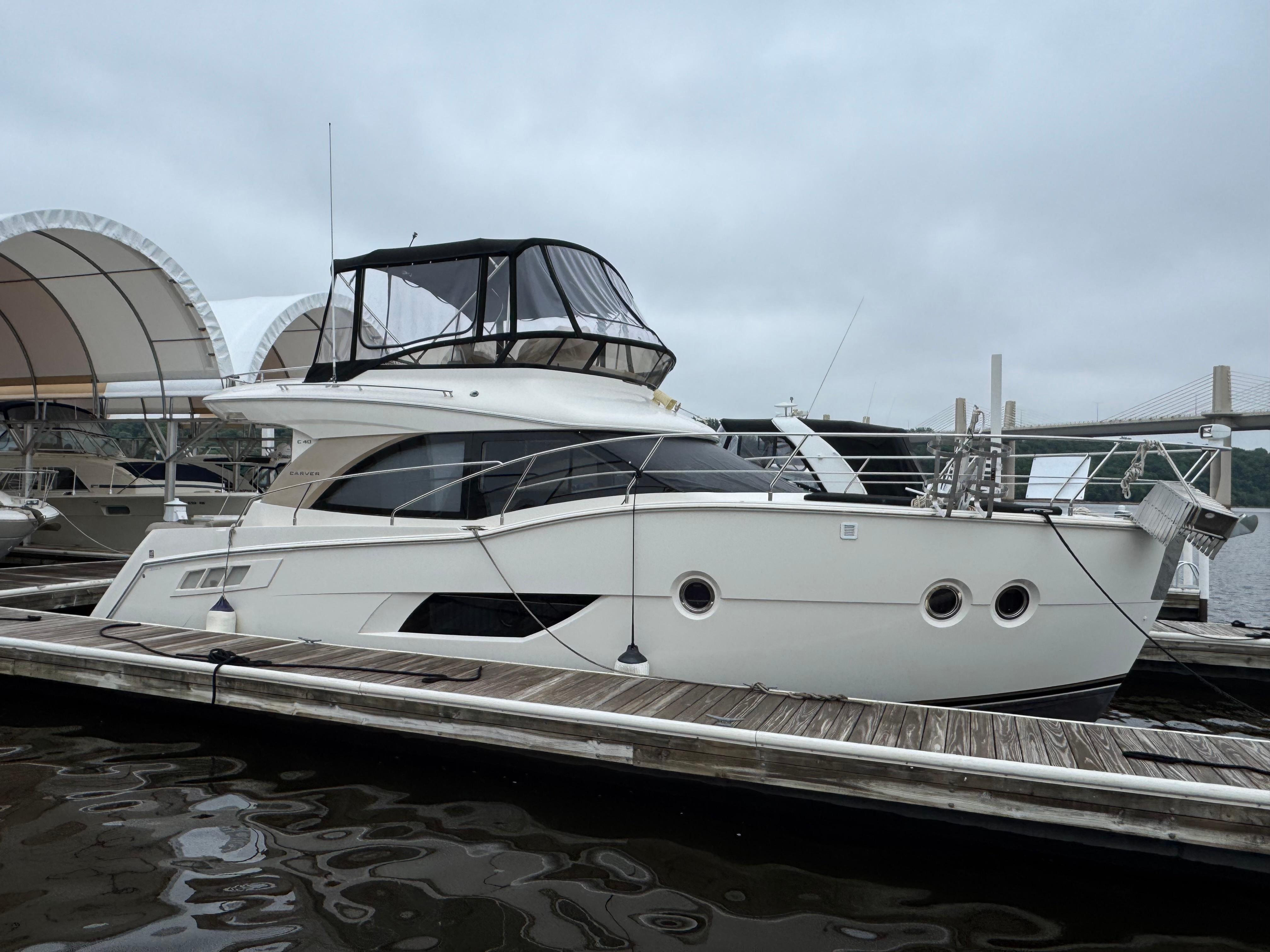 Carver C40 Command Bridge 2014 Carver C40 Command Bridge yacht docked at marina under cloudy sky.