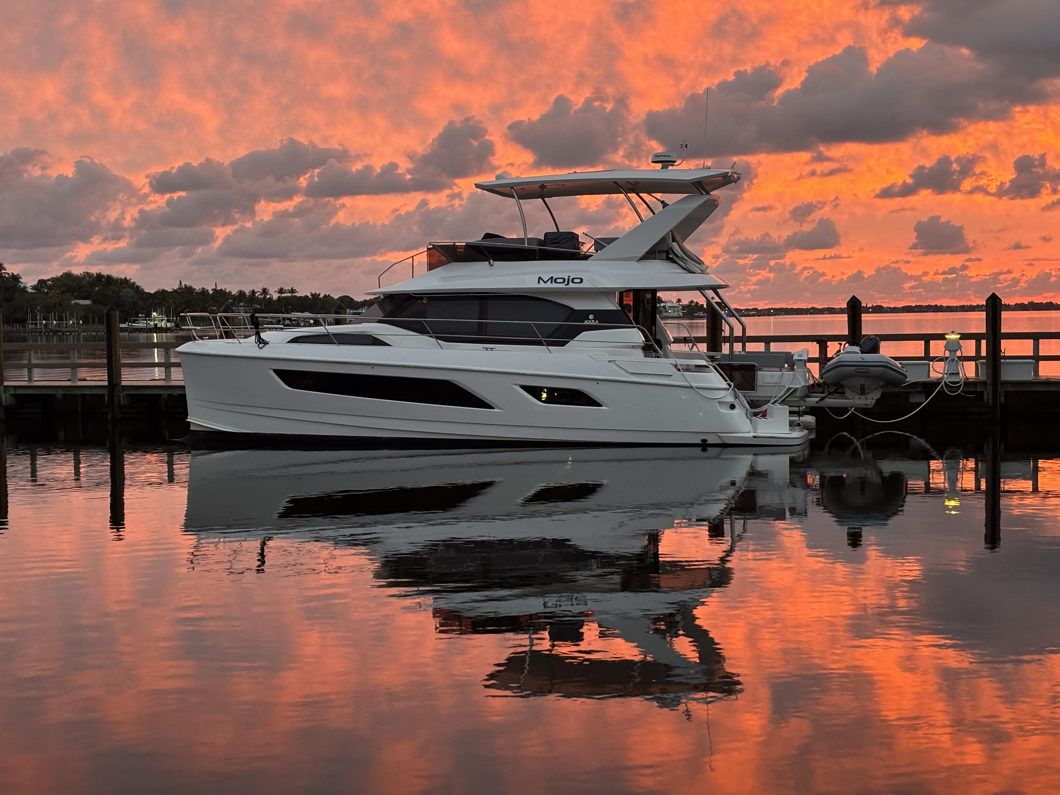 Aquila 44 Yacht Aquila 44 Yacht 2020 docked at sunset with vibrant sky reflection.