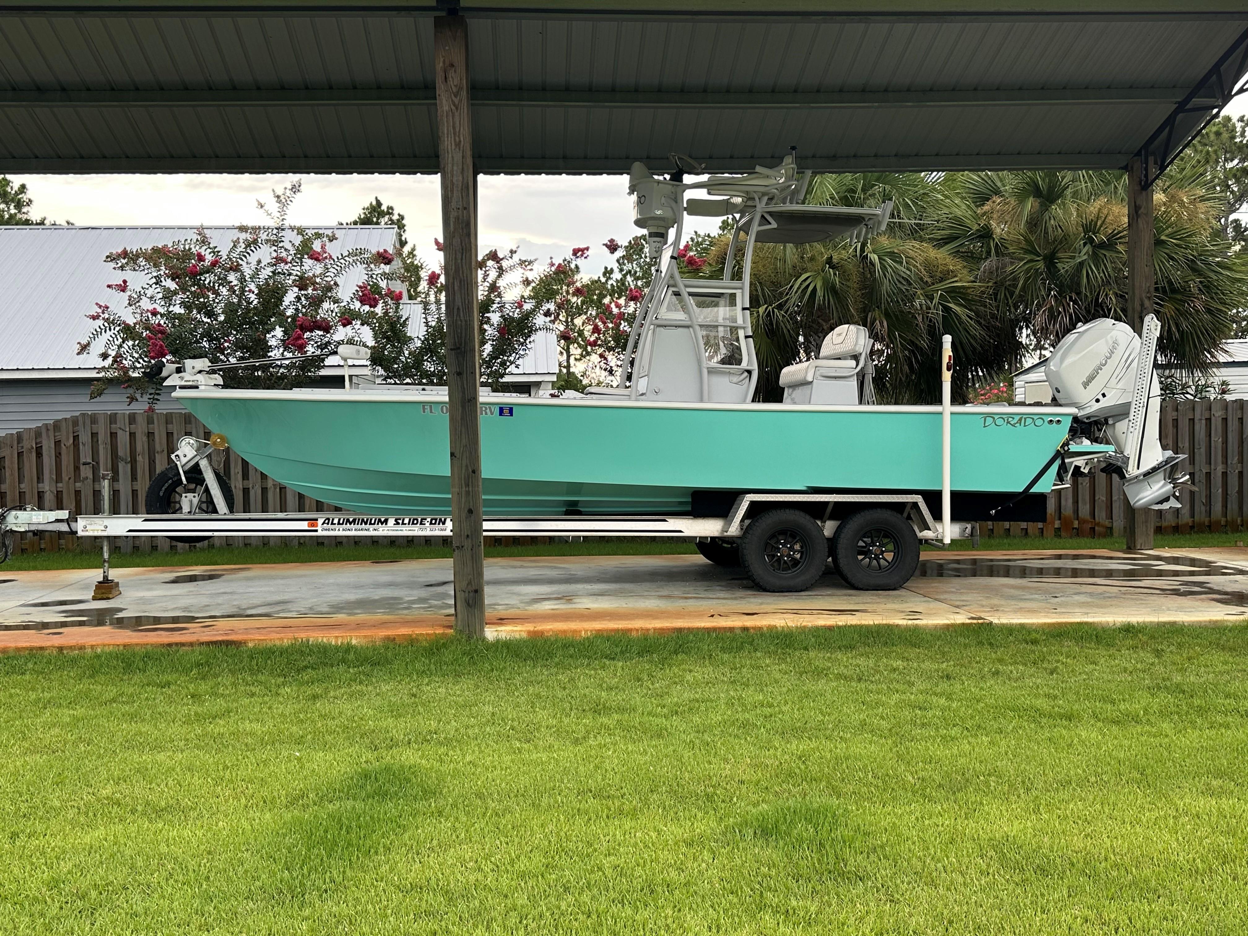 Dorado 25 Flat Deck 2019 Dorado 25 Flat Deck boat on trailer, parked under a shelter with lush greenery.
