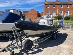 Ribcraft 7.8 2008 Ribcraft 7.8 boat on trailer, parked outdoors near brick buildings.
