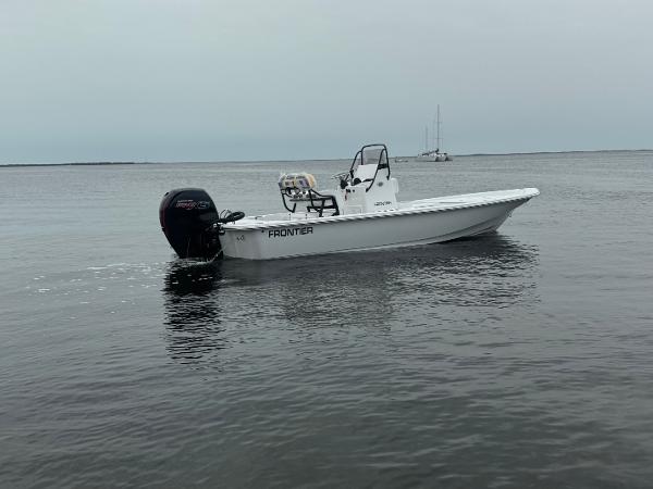 Frontier 2104 2025 Frontier 2104 boat on calm water, featuring a sleek design and powerful outboard motor.