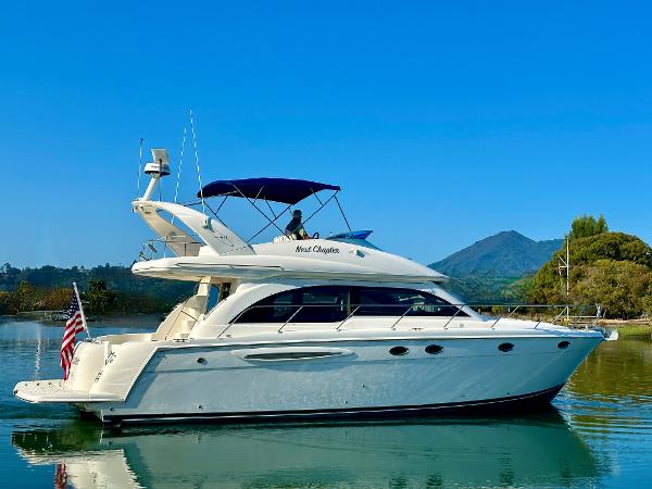 Meridian 411 Sedan 2003 Meridian 411 Sedan yacht on calm water with scenic mountain backdrop.