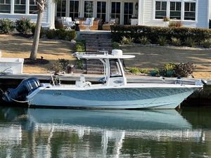 Sea Hunt Ultra 275 SE 2019 Sea Hunt Ultra 275 SE boat docked by a waterfront home.
