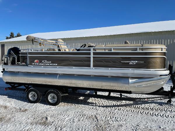 Sun Tracker SportFish 20 DLX 2024 Sun Tracker SportFish 20 DLX pontoon boat on trailer, parked outdoors.