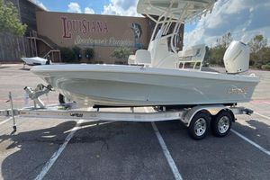 Mako 24 APEX 2026 Mako 24 APEX boat on trailer in parking lot, Louisiana Sportsman's Paradise backdrop.