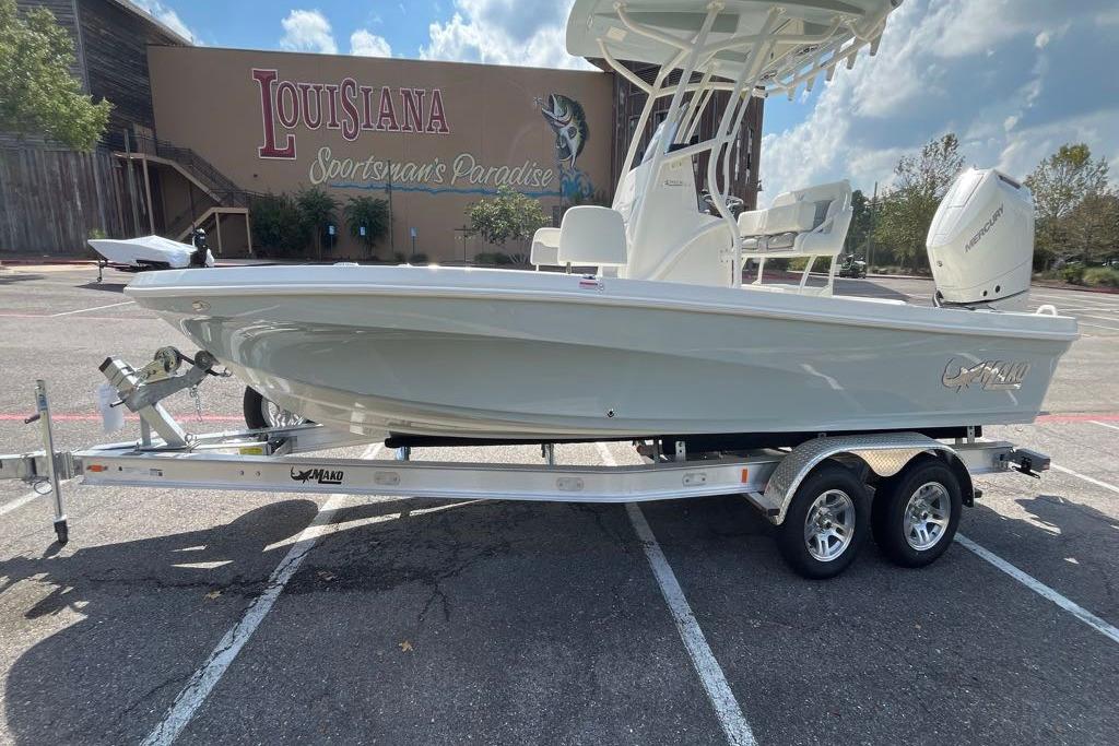 Mako 24 APEX 2026 Mako 24 APEX boat on trailer in parking lot, Louisiana Sportsman's Paradise backdrop.