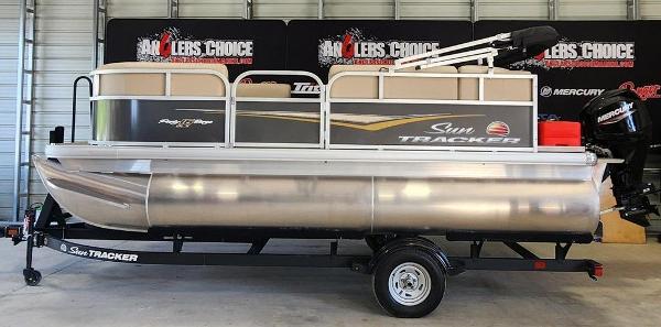 Sun Tracker Party Barge 16 DLX 2025 Sun Tracker PARTY BARGE® 16 DLX pontoon boat on trailer in showroom.