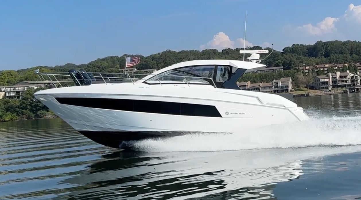 Cruisers Yachts 390 Express 2022 Cruisers Yachts 390 Express speeding on a serene lake with scenic background.