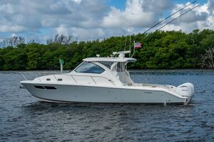 Pursuit OS 355 Offshore 2022 Pursuit OS 355 Offshore boat on water, surrounded by lush greenery.