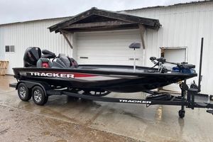 Tracker Savage 215 2026 Tracker Savage 215 boat on trailer, parked outside a white building.